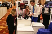 The expert is showing the visitors of OKOndt Group's booth company's portable eddy current flaw detectors at the APCNDT-2017 