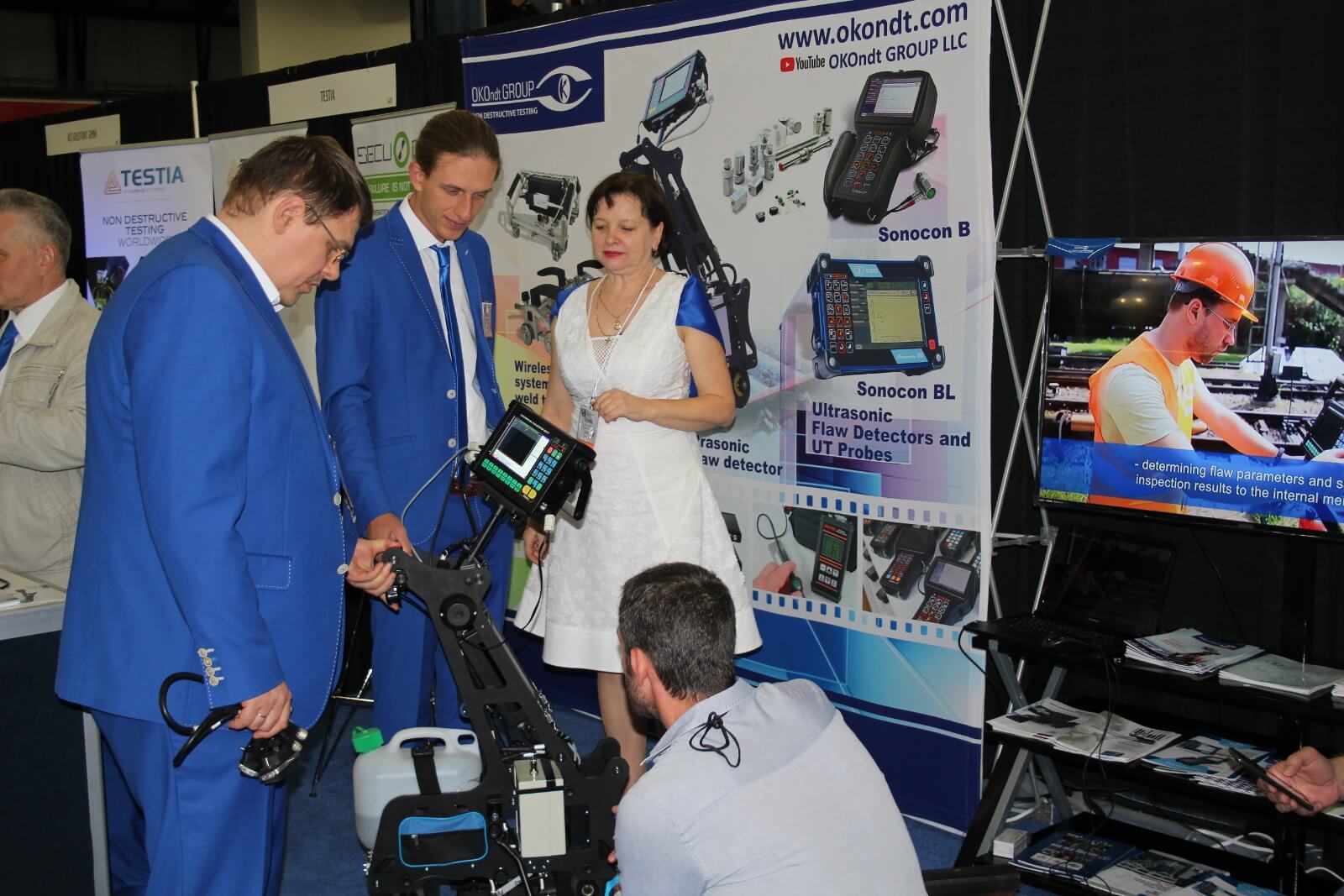 Representatives of OKOndt Group are showing Ultrasonic single-rail Flaw Detector UDS2-77 to the visitor of ASNT-2018