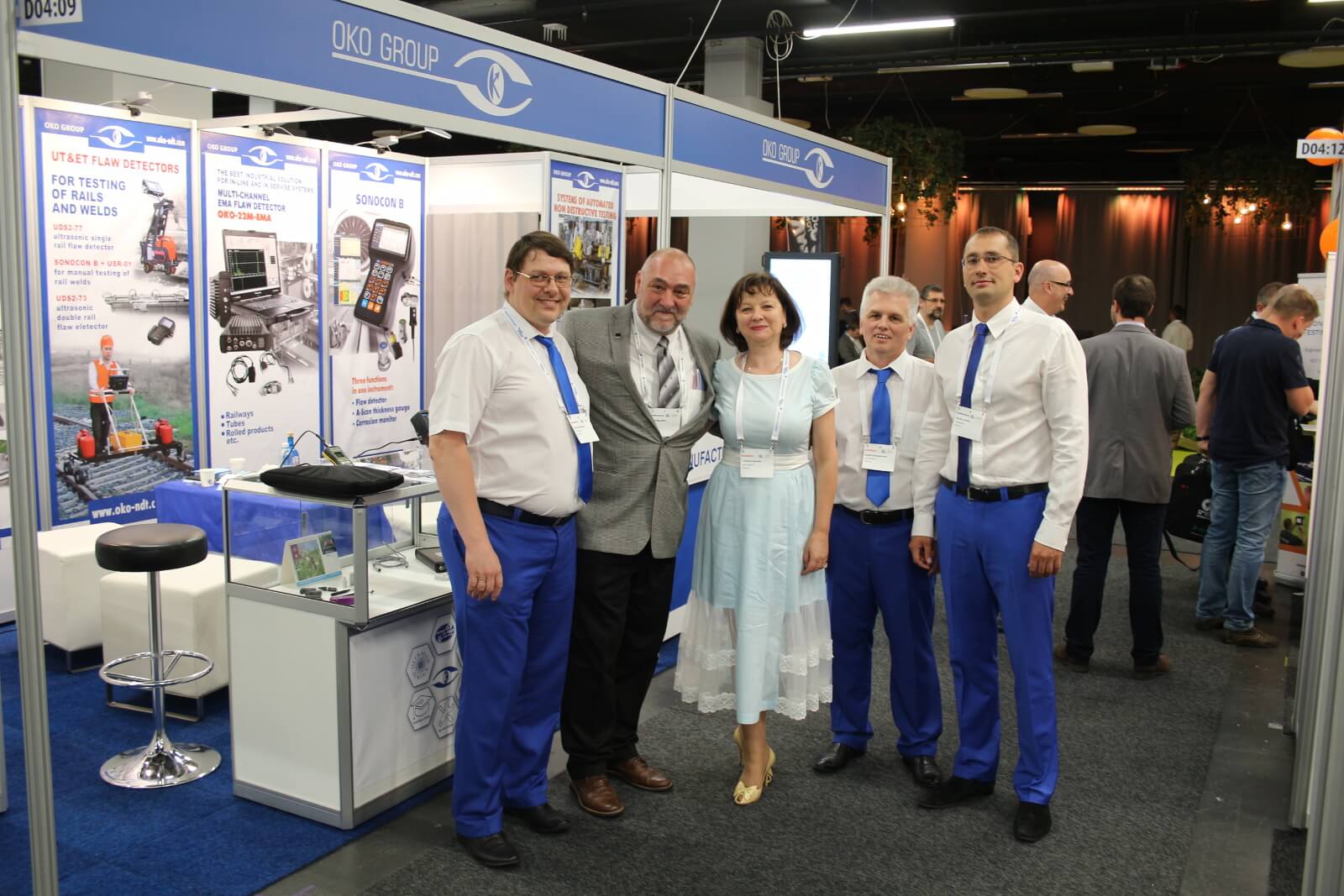 OKOndt Group team welcomes a guest —  ASNT Vice President D. Mandina at their booth at the 12th European conference of NDT, June 2018